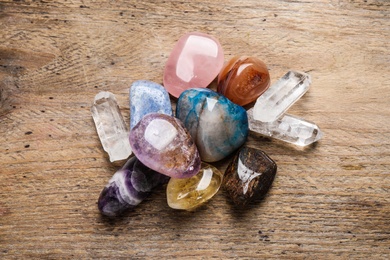 Flat lay composition with different gemstones on wooden table