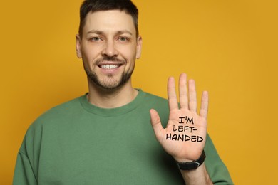 Left-handed man with open palm with text on yellow background