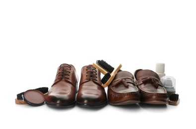 Stylish footwear and shoe care products on white background