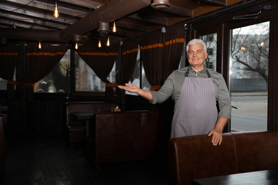 Senior male business owner in his restaurant