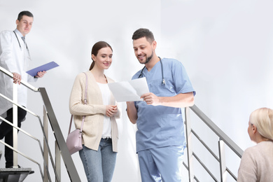 Doctor and patient discussing diagnosis on stairs in hospital