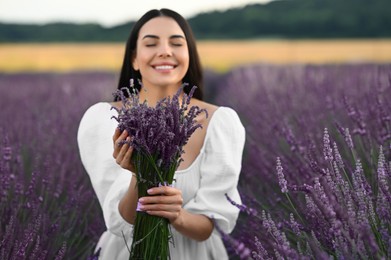 Beautiful young woman with bouquet in lavender field