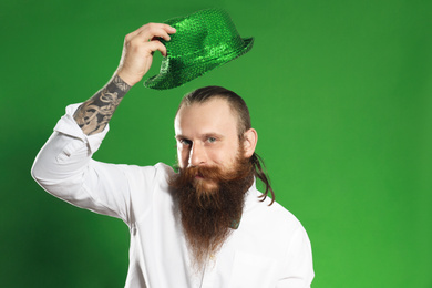 Bearded man with green hat on color background. St. Patrick's Day celebration