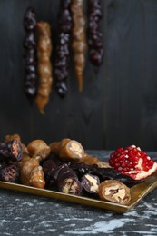 Photo of Delicious sweet churchkhelas and pomegranate on textured table