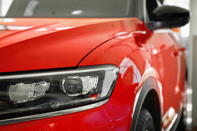 New luxury car in modern auto dealership, closeup