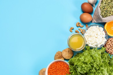 Food high in calcium. Flat lay composition with different products on light blue background, space for text