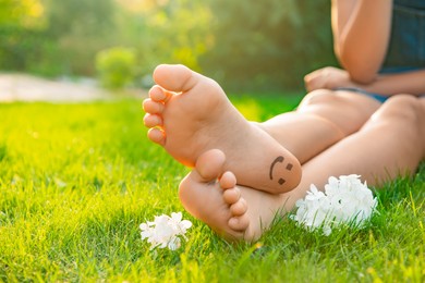 Teenage girl with beautiful hortensia flowers and smiling face drawn on heel outdoors, closeup. Space for text