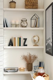 Bookends with books and decor on shelves indoors. Interior design