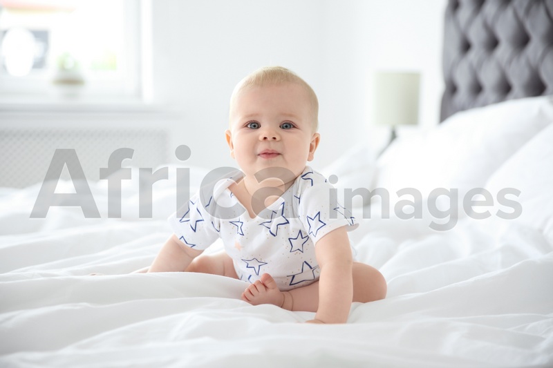 Photo of Cute little baby crawling on bed at home