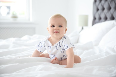 Cute little baby crawling on bed at home