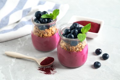 Tasty dessert with acai smoothie, granola and berries on marble table