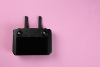 New modern drone controller on pink background, top view. Space for text