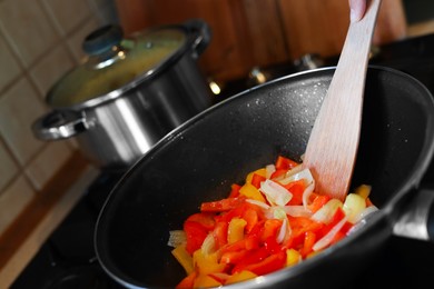 Cooking fresh vegetables in frying pan on stove, closeup