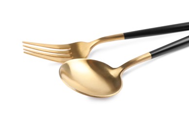 New golden fork and spoon with black handles on white background, closeup