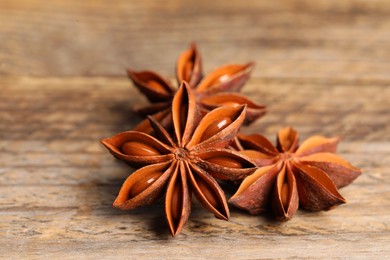 Aromatic anise stars on wooden table, closeup