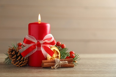 Beautiful composition with candle and Christmas decor on wooden table. Space for text