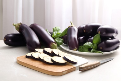 Photo of Cut and whole raw ripe eggplants on light table