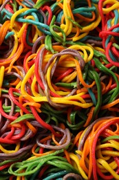 Photo of Spaghetti painted with different food colorings as background, top view