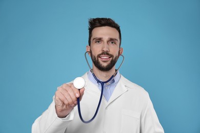 Doctor with stethoscope on light blue background. Cardiology concept