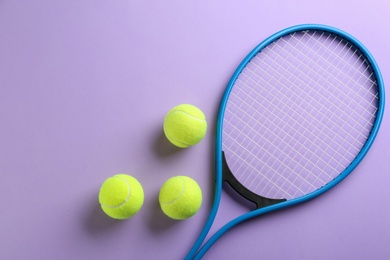 Tennis racket and balls on violet background, flat lay. Sports equipment