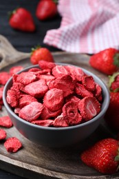 Freeze dried and fresh strawberries on wooden board, closeup