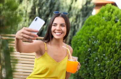 Photo of Beautiful woman taking selfie in deckchair at garden