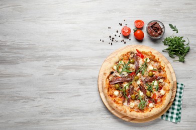 Photo of Tasty pizza with anchovies and ingredients on grey wooden table, flat lay. Space for text