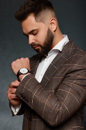 Handsome bearded man in stylish suit on dark background