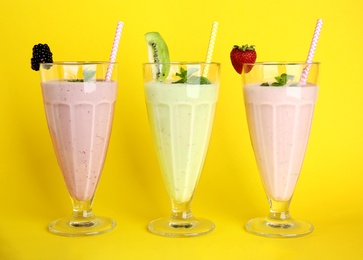 Tasty fresh milk shakes with berries on white background