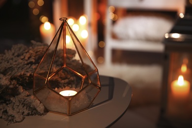 Photo of Stylish lantern with burning candle and Christmas decor on table indoors, space for text. Interior design
