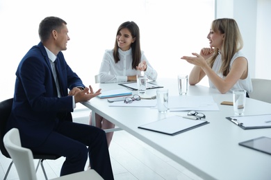 Office employees talking at table during meeting