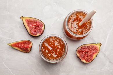 Homemade delicious fig jam on marble table, flat lay
