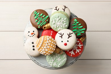 Beautifully decorated Christmas macarons on white wooden table, top view