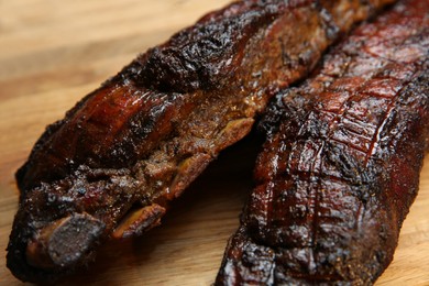 Tasty grilled pork ribs on wooden board, closeup