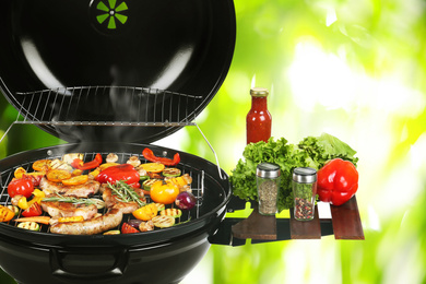 Image of Barbecue grill with meat products and vegetables on blurred green background, closeup