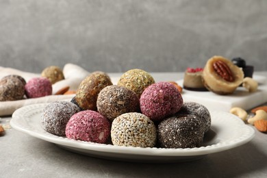 Different delicious vegan candy balls on grey table