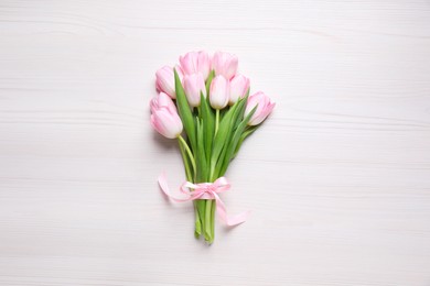 Beautiful pink spring tulips on white wooden background, top view