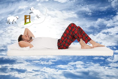 Image of Sweet dreams. Young man lying on matress and counting sheep jumping over fence in blue sky with clouds