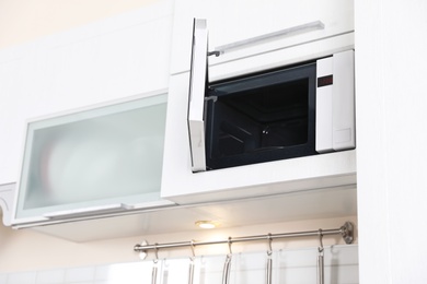 Photo of Open modern microwave oven built in kitchen furniture