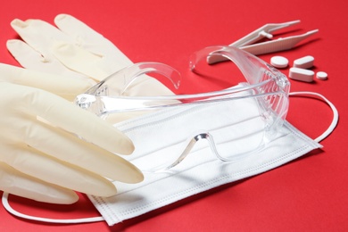 Sterile gloves with medical items on color background