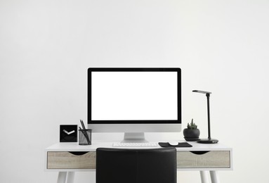 Modern computer with blank screen on desk, space for design. Comfortable workplace