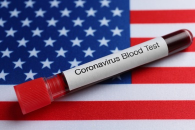 Test tube with blood sample on American flag. Coronavirus pandemic in USA