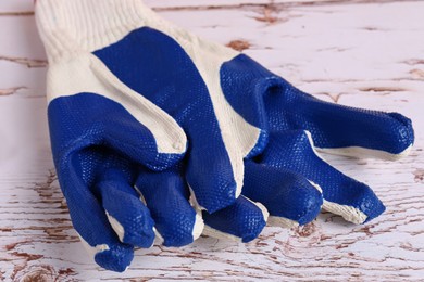 Photo of Gardening gloves on white wooden table, closeup