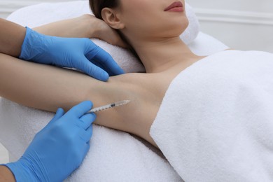 Cosmetologist injecting young woman's armpit, closeup. Treatment of hyperhidrosis