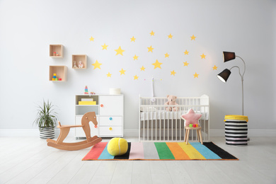 Stylish baby room interior with crib and toys