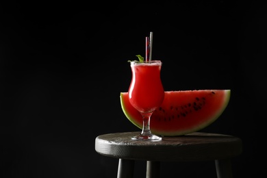 Tasty watermelon drink and fresh fruit on table against black background, space for text