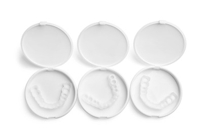 Photo of Dental mouth guards in containers on white background, top view. Bite correction