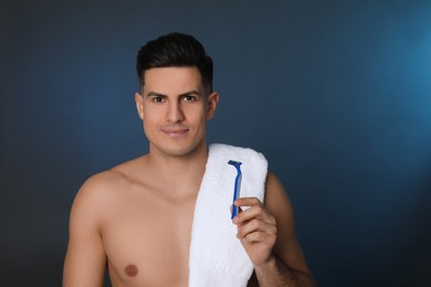 Handsome man with razor after shaving on blue background