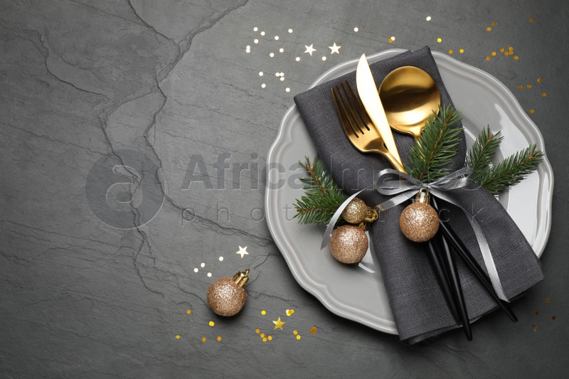 Festive table setting with beautiful dishware and Christmas decor on black background, flat lay. Space for text