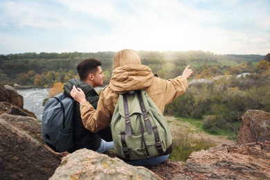 Couple of hikers with travel backpacks enjoying beautiful view of nature